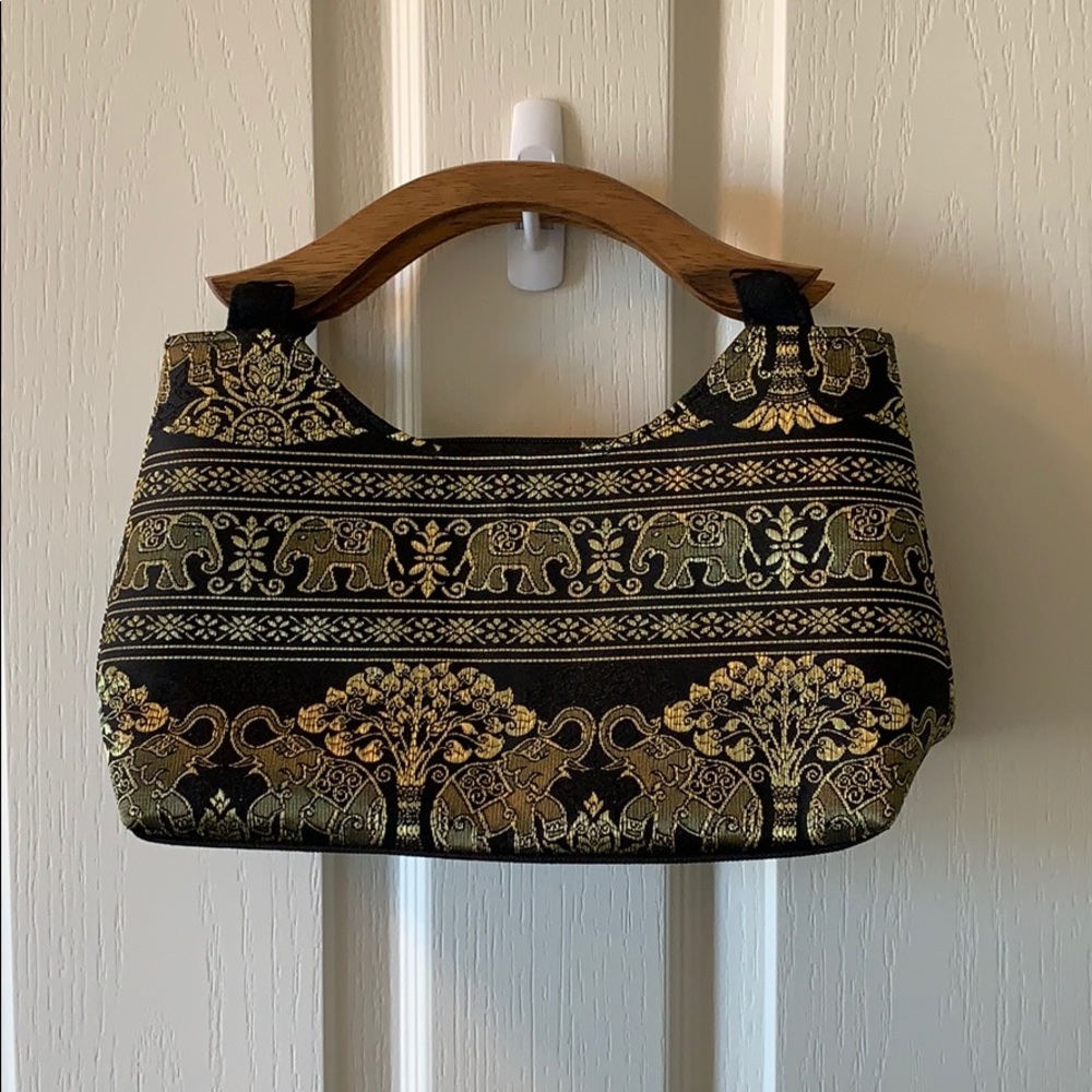 Black handbag with wood handles and gold elephants
